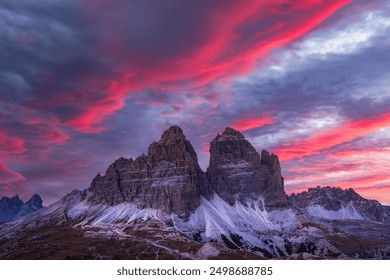 ラヴァレド山脈の 3 つの峰に沈む信じられないほどの紫色の夕日。イタリア、トレンティーノ・アルト・アディジェ州、ドロミテ・アルプス、トレ・チーメ・ディ・ラヴァレド国立公園のアウロンツォ避難所