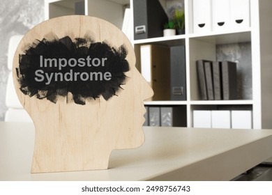Pisarna in model glave s frazo impostor syndrome.