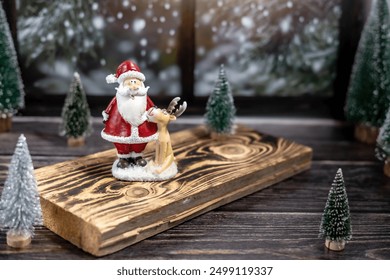 Sinterklas dan rusa kutub dari keramik, pohon Natal di papan kayu dekat jendela, kartu Natal, dekorasi rumah