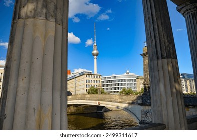 Високий будинок і позаду нього Berliner Fernsehturm – Берлінська телевежа розташована в берлінському районі Мітте, поблизу площі Александерплац, і має висоту 368 метрів і є найвищою будівлею в Німеччині.