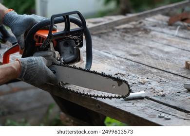 Motosierra rota. Hombre reparando una motosierra. Herramienta de jardinería. Repuestos de motosierra.