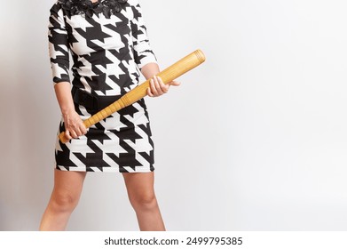 Grua në modë që mban në duar një shkop druri bejsbolli dhe tregon besim femëror