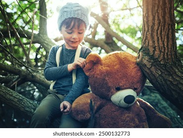 Boy, child and toys with bear in park with smile, playful and holiday in winter by trees with nature. Kid, teddy and animal plushy in forest for adventure, games and happy on vacation in Argentina