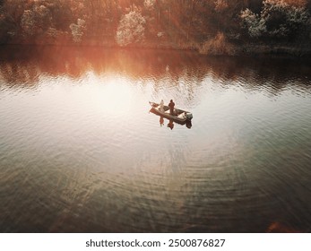 Pêcheur de bar pêchant à partir d'un bateau de pêche à l'achigan un après-midi d'automne. Photo prise par drone d'en haut.