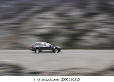 A moving car. High speed SUV with speed blur background. Side view.