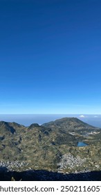Wonosobo, Indonesia - 11 de agosto de 2024: Monte Prau, un paisaje impresionante con imponentes colinas sobre un fondo de cielo azul claro y el campo de abajo.