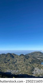 Wonosobo, Indonesia - 11 de agosto de 2024: Monte Prau, un paisaje impresionante con imponentes colinas sobre un fondo de cielo azul claro y el campo de abajo.