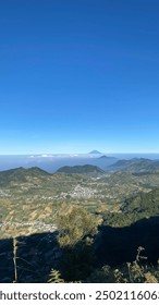 Wonosobo, Indonesia - 11 de agosto de 2024: Monte Prau, un paisaje impresionante con imponentes colinas sobre un fondo de cielo azul claro y el campo de abajo.