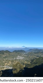 Wonosobo, Indonesia - 11 de agosto de 2024: Monte Prau, un paisaje impresionante con imponentes colinas sobre un fondo de cielo azul claro y el campo de abajo.
