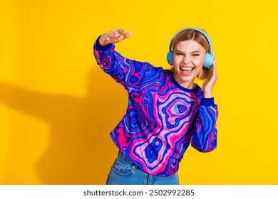 Photo portrait of pretty young girl dance headphones listen music wear trendy colorful blue outfit isolated on yellow color background