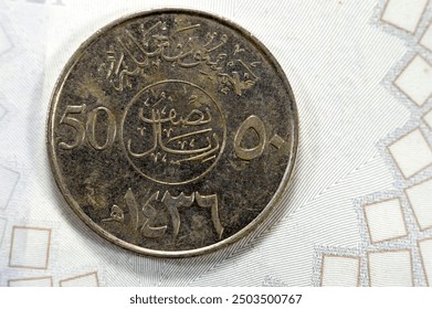 Moneta da 50 Halalas mezzo Riyal SAR dell'Arabia Saudita, raffigura una palma con spade incrociate e il nome del re Abdullah Bin AbdulAziz sul dritto, legenda sopra l'iscrizione, valore di divisione, data sul retro