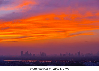 Pemandangan petang siluet bangunan dan bangunan pencakar langit, langit yang hampir mati selepas matahari terbenam dan awan merah yang menakjubkan.