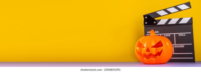 Horror movie, series night, Halloween cinema party with trick-or-treating sweets bucket, popcorn, movie clapperboard and Halloween decorations on high-colored background copy space