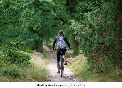 A woman cyclist on a forest road