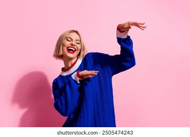 Photo portrait young girl wearing blue knitted sweater boogie woogie weekend of clubber raised hands up isolated on pink color background