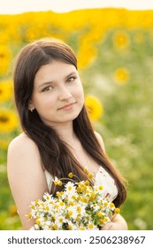 linda adolescente com cabelos longos e um buquê de margaridas nas mãos em um prado florido em uma noite de verão. Retrato gentil