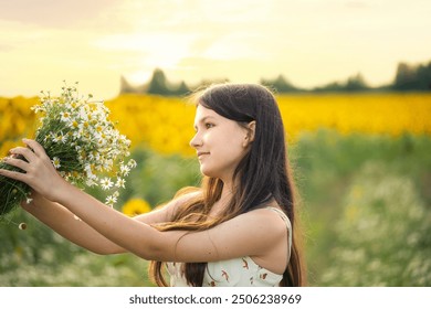 linda adolescente com cabelos longos e um buquê de margaridas nas mãos em um prado florido em uma noite de verão. Retrato gentil