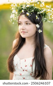 Uma linda adolescente com longos cabelos escuros e uma coroa de margaridas na cabeça. retrato em close-up