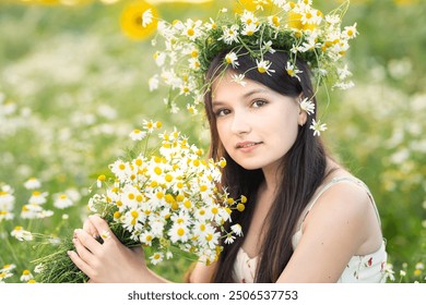 Uma linda adolescente com cabelos longos e uma coroa de flores de margarida na cabeça e um buquê de margaridas nas mãos em um campo florido. Retrato fofo de verão