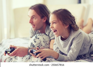 Kind spielt Videospiel im Fernsehen mit Vater morgens im Bett zu Hause