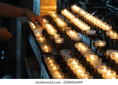Memorial Day And Light Candles In The Catholic Church. Woman Hand Lighting Candle.