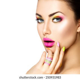 Beauty Girl Portrait with Colorful Makeup, Nail polish and ring Accessories. Colourful eyeshadows make-up. Studio Shot of Stylish Woman. Vivid Colors. Manicure and Hairstyle. Rainbow Colours 