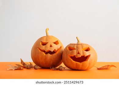 Kungujt e gdhendur për Halloween, gjethet e vjeshtës dhe lisat në sfond me ngjyra