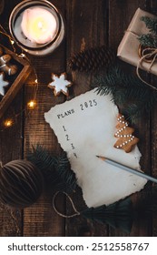 12月の大晦日に2025年の新年の抱負を手書きで書きます。計画、目標、アイデア、プロジェクト。居心地の良い家庭の休日の雰囲気、クリスマスのイルミネーション、お祭りの装飾、手作りのジンジャーブレッドクッキー