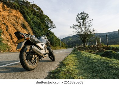 Moto garée sur la route, scène rurale et nature. Voyages et expériences.