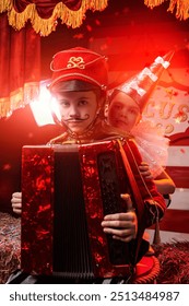 Ein Junge im Husarenkostüm spielt Akkordeon, während er in der Zirkusarena sitzt. Goldene Lichter leuchten umher. Zirkusvorstellung. Retro-Stil.