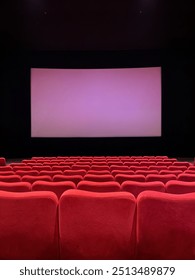 Skrin besar dengan deretan tempat duduk merah di panggung wayang