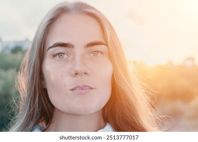 Amber Golden Hour Nga afër një grua e larë në dritën e orës së artë duke bërë selfie në perëndimin e diellit në parkun veror. Turisti i lumtur kënaqet duke bërë foto selfie jashtë për kujtime