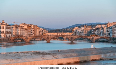 Sunset skyline timelapse view of Tuscany City, Housing, Buildings and Ponte alla Carraia and Arno River at summer Day, Florence, Italy. Orange warm light
