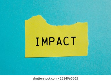 Mot d'impact écrit sur du papier jaune déchiré avec un fond bleu. Symbole de mot d'impact conceptuel. Espace de copie.