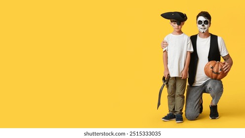 Papp a säi klenge Jong verkleed fir Halloween als Piraten op gielem Hannergrond mat Plaz fir Text