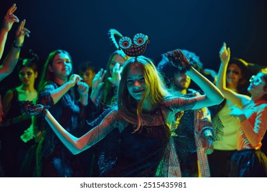 Des amis portant divers costumes d'Halloween se réunissent dans une boîte de nuit pour une célébration joyeuse et énergique. Danser et rire. Concept d'Halloween, vacances, fête, loisirs