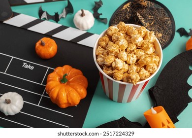 Papan bertepuk filem dan hiasan Halloween dengan popcorn berlatar belakang hijau, pesta teater dan labu, hiburan bertepuk tangan filem menakutkan, helah percutian dan snek.