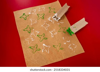 Sellos decorativos hechos a mano con un rollo de papel higiénico y pintura, ideales para papel de regalo personalizado y tarjetas de felicitación. Tutorial sencillo paso a paso para hacer decoraciones de papel creativas.