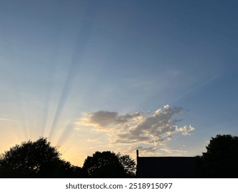 Tramonto sulla chiesa del villaggio con raggi di sole sugli alberi