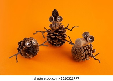 Meșteșuguri creative de toamnă în natură pentru copii cu creaturi de conuri de pin, surprinse din vedere de sus. Ideal pentru activități pentru copii, combinând distracția, învățarea și explorarea naturii