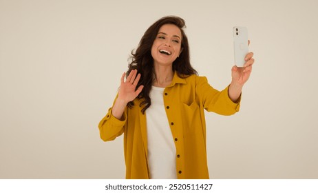 Happy Caucasian woman vlogger influencer streamer waving hand greeting smile filming video blogger girl female stream broadcasting mobile phone walking show studio talk speak to subscribers blog vlog
