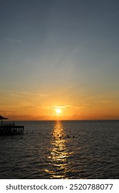Langit Matahari Terbenam di atas Laut pada Waktu Petang dengan Sinaran Matahari Emas dan Matahari pada langit Cakrawala Senja Jingga berwarna-warni Latar belakang dengan kabur gerakan permukaan air laut yang mengalir, Latar belakang langit Pagi yang Indah