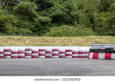 Intrare pe o pistă de kart, imaginea arată o pistă de kart în aer liber, cu intrarea pe calea de boxe care permite karturilor să iasă de pe pistă în boxe