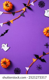 Halloween-Rahmen aus Wimpel, Geistern, Kürbissen, Netz, Fledermäusen, Spinnen auf violettem Hintergrund. Flache Lage, Draufsicht, Kopierraum.