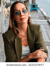 Eng stilvoll Fra, déi mat Schicht Gold an Diamant Bijouen dekoréiert ass, dorënner Kette, Braceleten, Réng.