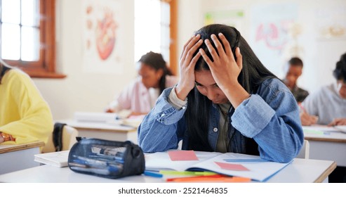 Frustrated girl, student and book with stress for exam, test or evaluation in classroom at school. Young, female person or teenager with migraine, anxiety or nerves for bad assesment or assignment