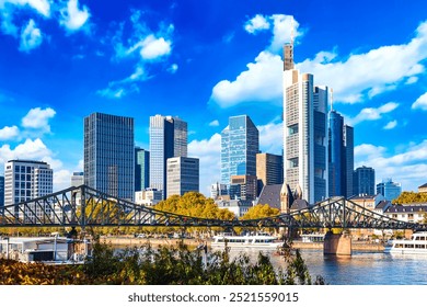 Frankfurt Main Iron footbridge against financial district skyscrapers with blue sky. Skyline cityscape of Frankfurt, Germany during sunny day. Frankfurt is a financial capital of Europe