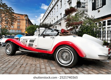 Ein klassischer Oldtimer steht elegant auf dem Kopfsteinpflaster von Kensington und verkörpert zeitloses Design und lokalen Charme.