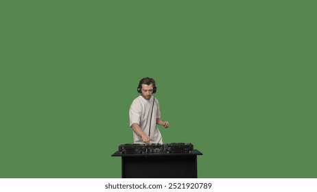 스튜디오에서 그린 스크린 배경 위에 턴테이블로 음악을 믹싱하는 DJ
