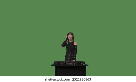 녹색 배경의 스튜디오에서 음악을 믹싱하는 여성 DJ